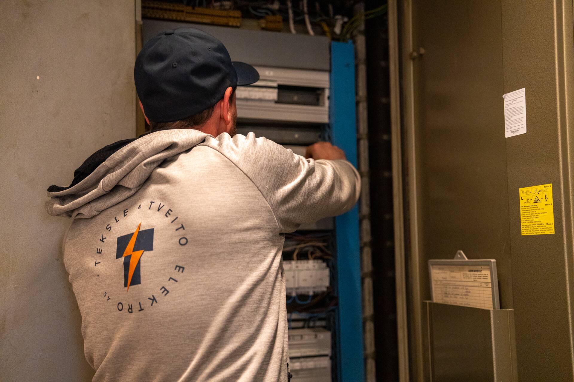 Montør i TT Elektro-tøy jobber i sikringsskap